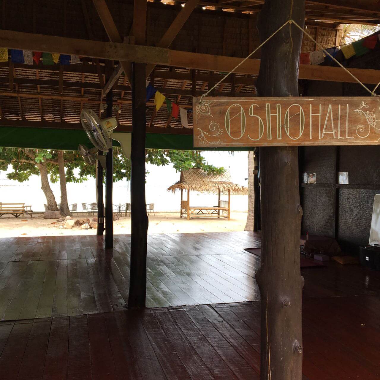 The inside of a wooden building with a sign that reads OSHO HALL