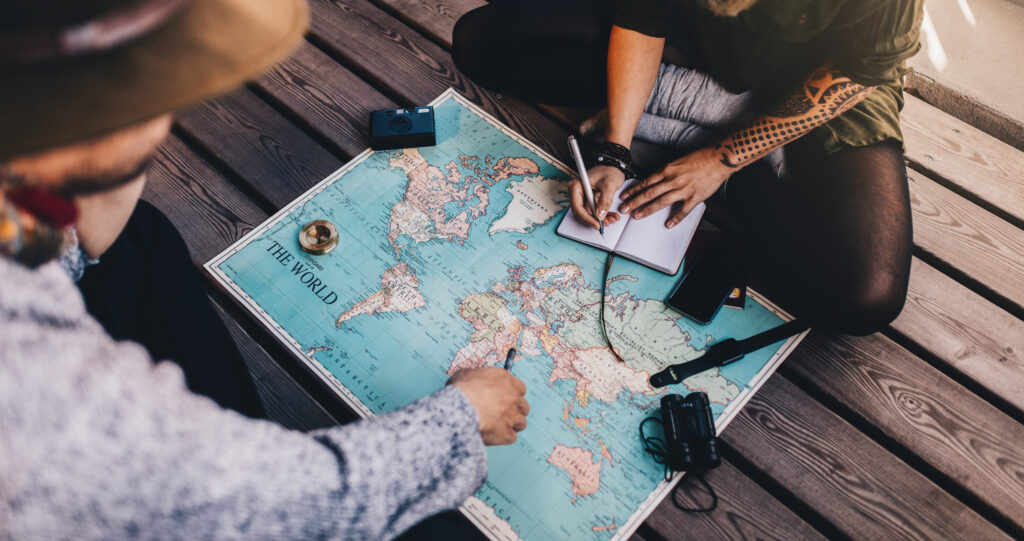 Two people sitting around a map of the world