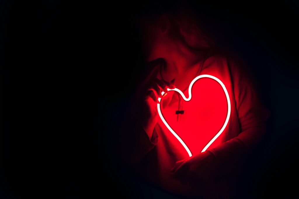 A red neon sign in the shape of a heart