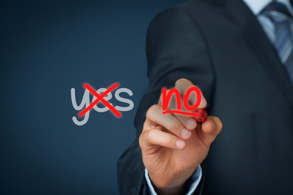 A man crossing out the word YES and writing NO in red marker