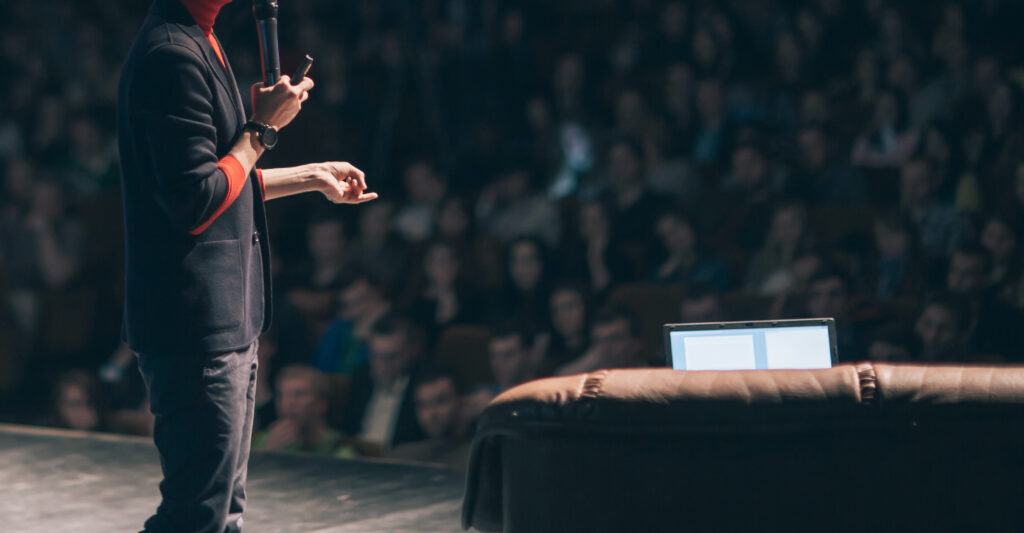 speaker makes a presentation on stage at  aeminar