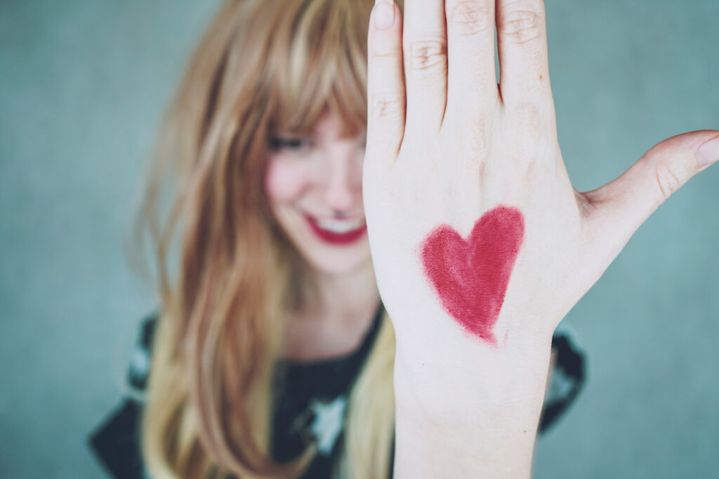 A woman with a red heart drawing in her hand