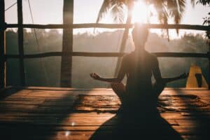 Woman meditating in the morning to ease burnout and lower cortisol
