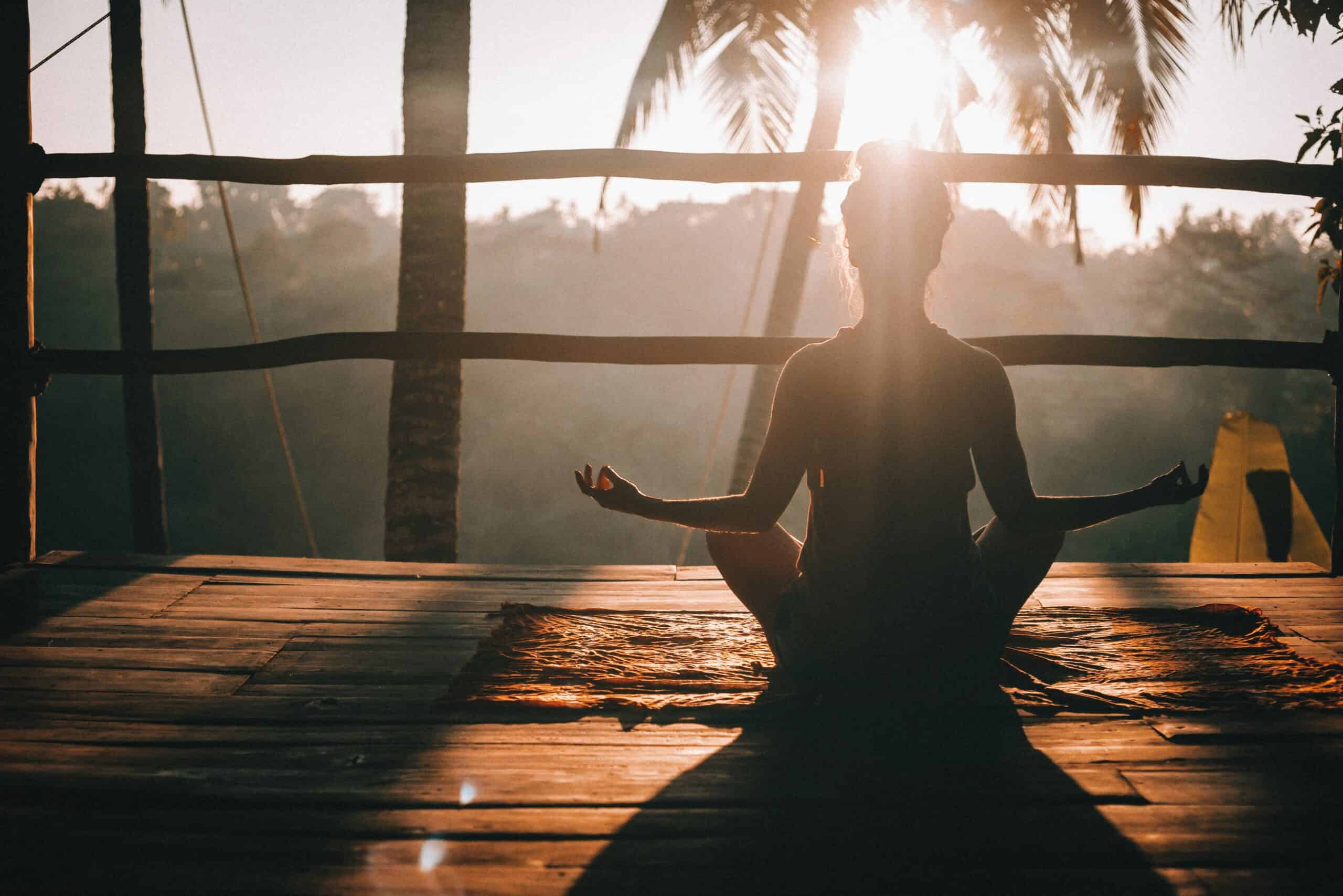 Woman meditating in the morning to ease burnout and lower cortisol