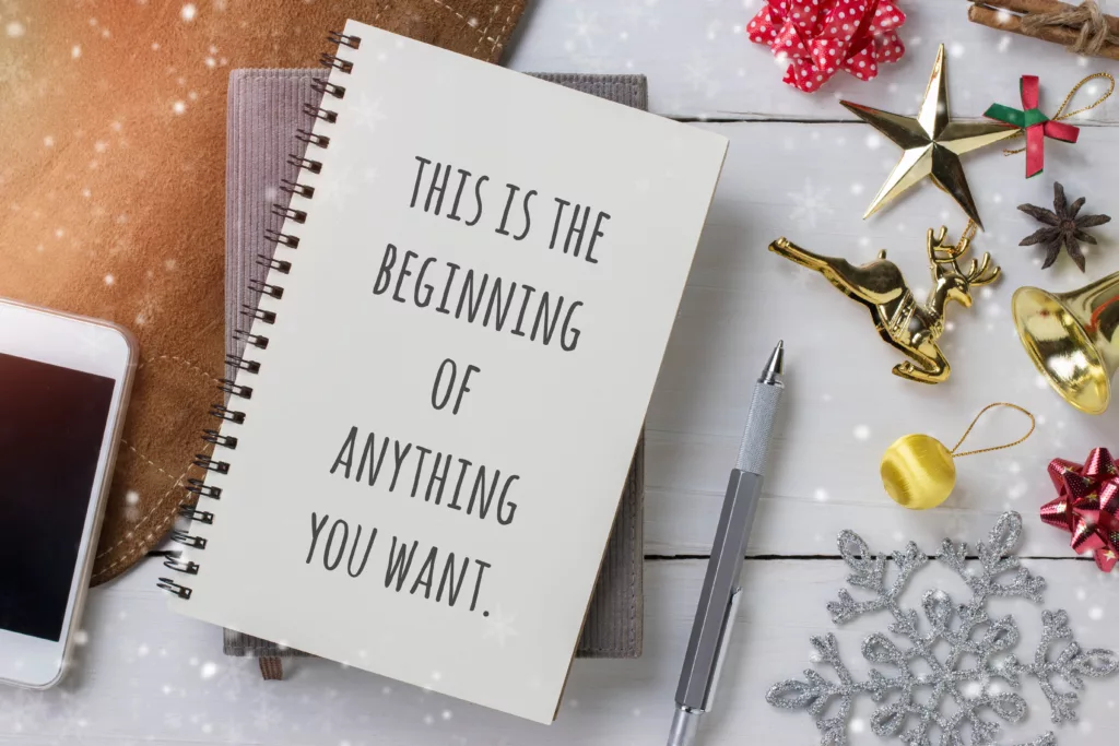 A notepad sitting on a desk.  The cover says "This is the beginning of anything you want" 
