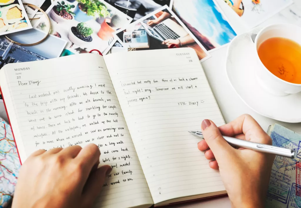 A person writing in a paper journal