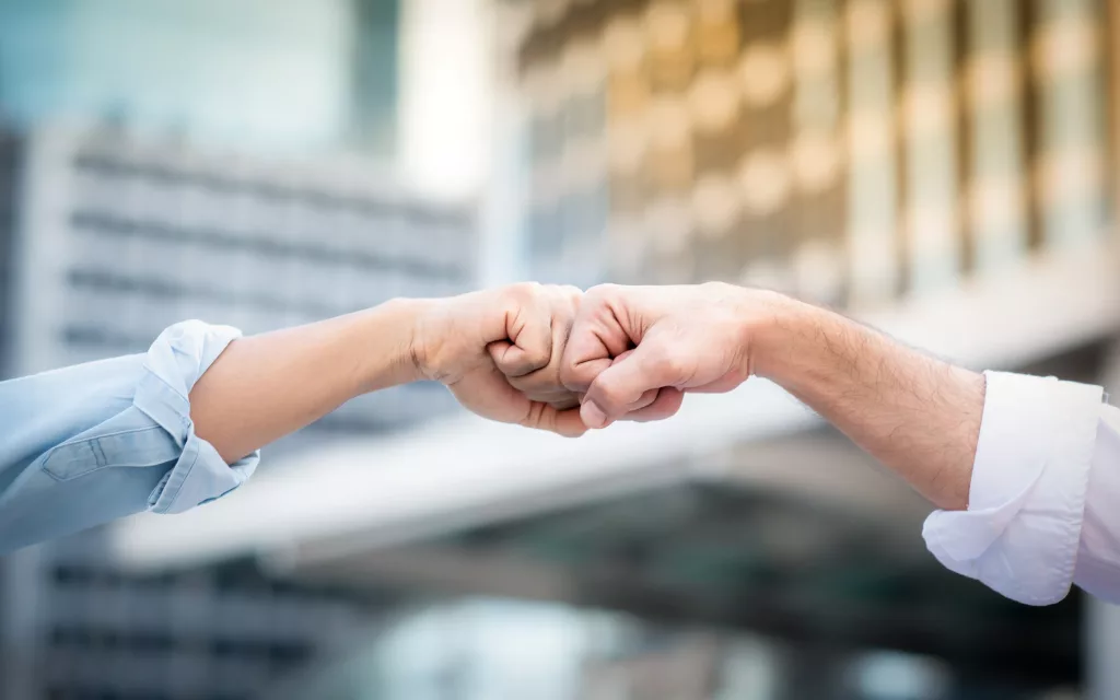 Two people fist bumping 