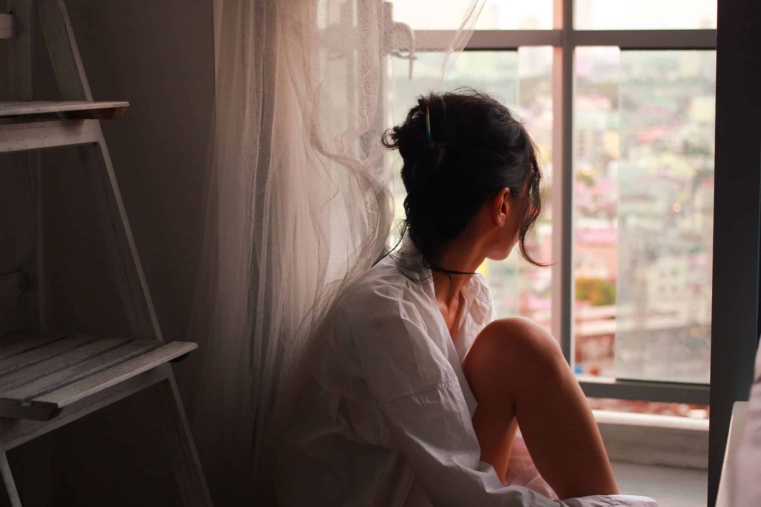 A woman who doesn't feel like herself anymore, seen through glass